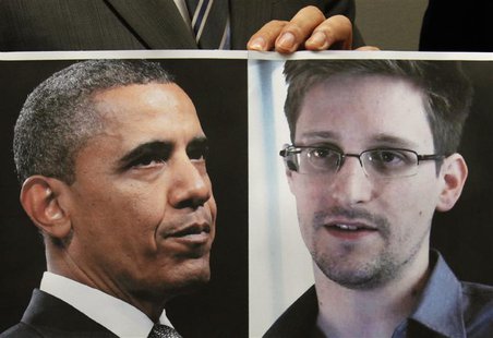 Pro-democracy lawamaker Gary Fan holds a combination photo featuring U.S. President Barack Obama (L) and Edward Snowden, a contractor at the Pro-democracy lawamaker Gary Fan holds a combination photo featuring U.S. President Barack Obama (L) and Edward Snowden, a contractor at the
