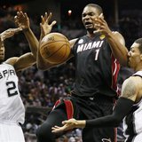 Miami Heat's Chris Bosh (L) loses control of the ball while going to the net between San Antonio Spurs' Kawhi Leonard (L) and Danny Green du