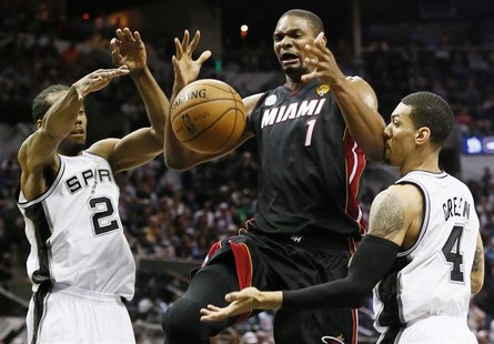 Miami Heat's Chris Bosh (L) loses control of the ball while going to the net between San Antonio Spurs' Kawhi Leonard (L) and Danny Green du Miami Heat's Chris Bosh (L) loses control of the ball while going to the net between San Antonio Spurs' Kawhi Leonard (L) and Danny Green du
