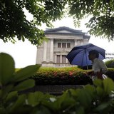 A pedestrian holding an umbrella walks past the Bank of Japan building in Tokyo June 11, 2013. REUTERS/Yuya Shino A pedestrian holding an umbrella walks past the Bank of Japan building in Tokyo June 11, 2013. REUTERS/Yuya Shino