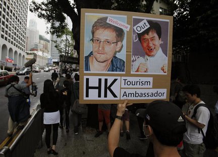 A protester supporting Edward Snowden, a former contractor at the National Security Agency (NSA), holds a placard showing pictures of Snowde A protester supporting Edward Snowden, a former contractor at the National Security Agency (NSA), holds a placard showing pictures of Snowde