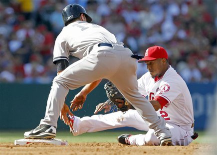 Los Angeles Angels shortstop Erick Aybar (R) takes a seat as the throw from the catcher takes him away from second base with New York Yankee Los Angeles Angels shortstop Erick Aybar (R) takes a seat as the throw from the catcher takes him away from second base with New York Yankee