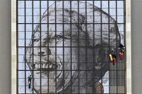 Rope access technicians work to complete a huge portrait of former South African President Nelson Mandela on the windows of the Civic Centre Rope access technicians work to complete a huge portrait of former South African President Nelson Mandela on the windows of the Civic Centre