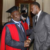 Jamaica's Olympic sprinter Usain Bolt (R) congratulates his coach Glen Mills after Mills received the degree of Doctor Honoris Causa from th Jamaica's Olympic sprinter Usain Bolt (R) congratulates his coach Glen Mills after Mills received the degree of Doctor Honoris Causa from th