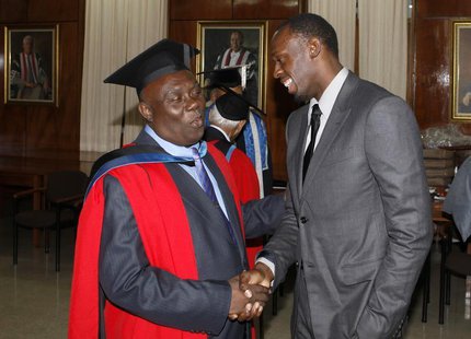 Jamaica's Olympic sprinter Usain Bolt (R) congratulates his coach Glen Mills after Mills received the degree of Doctor Honoris Causa from th Jamaica's Olympic sprinter Usain Bolt (R) congratulates his coach Glen Mills after Mills received the degree of Doctor Honoris Causa from th