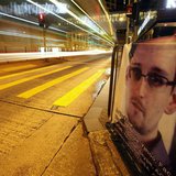 A bus passes by a poster of Edward Snowden, a former contractor at the National Security Agency (NSA), displayed by his supporters at Hong K