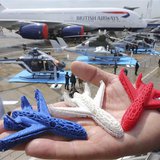 An Airbus employee presents three model airplanes in blue, white and red, made from starch using a 3D printing technique during the opening An Airbus employee presents three model airplanes in blue, white and red, made from starch using a 3D printing technique during the opening