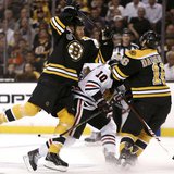 Boston Bruins' Shawn Thornton (22) and Kaspars Daugavins (16) collide with Chicago Blackhawks center Patrick Sharp (10) during the first per Boston Bruins' Shawn Thornton (22) and Kaspars Daugavins (16) collide with Chicago Blackhawks center Patrick Sharp (10) during the first per