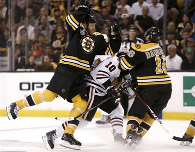 Boston Bruins' Shawn Thornton (22) and Kaspars Daugavins (16) collide with Chicago Blackhawks center Patrick Sharp (10) during the first per Boston Bruins' Shawn Thornton (22) and Kaspars Daugavins (16) collide with Chicago Blackhawks center Patrick Sharp (10) during the first per