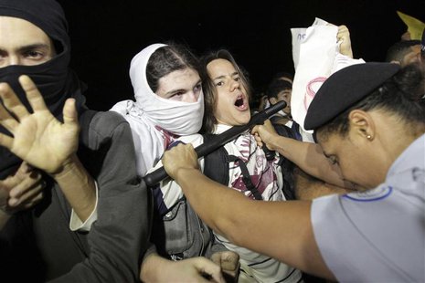 Police uses a baton to control demonstrators as they protest against the Confederation's Cup and the government of Brazil's President Dilma Police uses a baton to control demonstrators as they protest against the Confederation's Cup and the government of Brazil's President Dilma