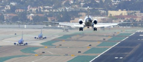 A passenger plane approaches to land as other aircraft taxi to the runway at the San Diego International Airport in San Diego, California, A A passenger plane approaches to land as other aircraft taxi to the runway at the San Diego International Airport in San Diego, California, A