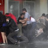 Anti-government protesters try to protect themselves from a water cannon as riot police disperse them during a protest in Ankara June 5, 201 Anti-government protesters try to protect themselves from a water cannon as riot police disperse them during a protest in Ankara June 5, 201