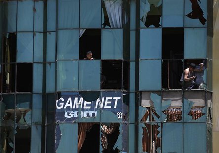 An Afghan shopkeeper removes the broken window glass of his shop near the site of an explosion in Kabul June 18, 2013. REUTERS/Mohammad Isma An Afghan shopkeeper removes the broken window glass of his shop near the site of an explosion in Kabul June 18, 2013. REUTERS/Mohammad Isma