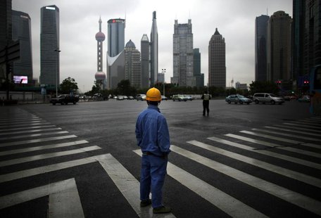A construction worker looks at Pudong financial district as he wait to cross an avenue in Shanghai May 30, 2013. REUTERS/Carlos Barria A construction worker looks at Pudong financial district as he wait to cross an avenue in Shanghai May 30, 2013. REUTERS/Carlos Barria