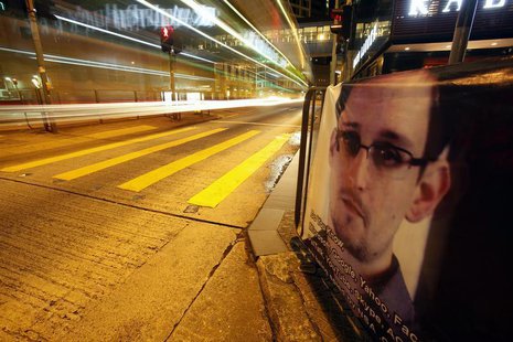 A bus passes by a poster of Edward Snowden, a former contractor at the National Security Agency (NSA), displayed by his supporters at Hong K A bus passes by a poster of Edward Snowden, a former contractor at the National Security Agency (NSA), displayed by his supporters at Hong K