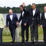 Britain's Prime Minister David Cameron (C) arrives for a group photo with (L-R) German Chancellor Angela Merkel, Russia's President Vladimir