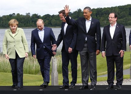 Britain's Prime Minister David Cameron (C) arrives for a group photo with (L-R) German Chancellor Angela Merkel, Russia's President Vladimir Britain's Prime Minister David Cameron (C) arrives for a group photo with (L-R) German Chancellor Angela Merkel, Russia's President Vladimir