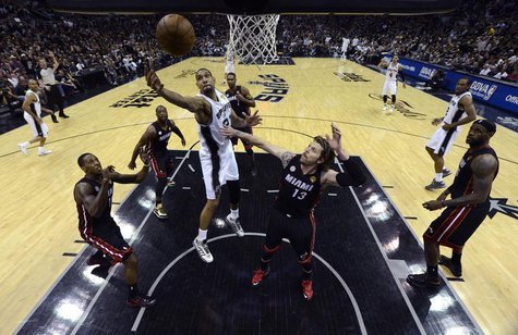 San Antonio Spurs power forward Tim Duncan (21) goes to the basket past Miami Heat shooting guard Mike Miller (13) during Game 5 of their NB San Antonio Spurs power forward Tim Duncan (21) goes to the basket past Miami Heat shooting guard Mike Miller (13) during Game 5 of their NB