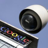 The Google logo is seen on the top of its China headquarters building behind a road surveillance camera in Beijing January 26, 2010. REUTERS