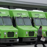 A worker walks past Amazon Fresh delivery vans parked at an Amazon Fresh warehouse in Inglewood, California, June 14, 2013. REUTERS/Jonathan