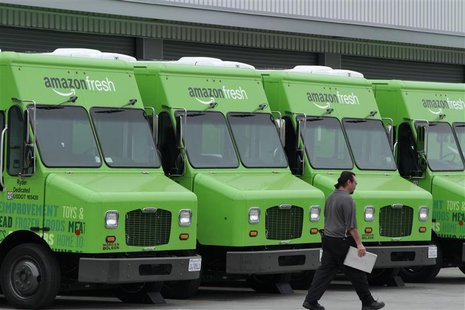 A worker walks past Amazon Fresh delivery vans parked at an Amazon Fresh warehouse in Inglewood, California, June 14, 2013. REUTERS/Jonathan A worker walks past Amazon Fresh delivery vans parked at an Amazon Fresh warehouse in Inglewood, California, June 14, 2013. REUTERS/Jonathan