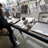 A woman surfs the Internet on a computer for visitors at a registration desk at South Korean mobile carrier KT's headquarters in Seoul Decem