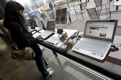 A woman surfs the Internet on a computer for visitors at a registration desk at South Korean mobile carrier KT's headquarters in Seoul Decem A woman surfs the Internet on a computer for visitors at a registration desk at South Korean mobile carrier KT's headquarters in Seoul Decem