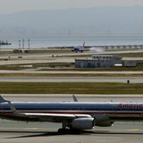 An American Airlines passenger jet taxis to a runway as a Southwest Airlines jet (rear) lands at San Francisco International Airport in San An American Airlines passenger jet taxis to a runway as a Southwest Airlines jet (rear) lands at San Francisco International Airport in San