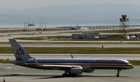 An American Airlines passenger jet taxis to a runway as a Southwest Airlines jet (rear) lands at San Francisco International Airport in San An American Airlines passenger jet taxis to a runway as a Southwest Airlines jet (rear) lands at San Francisco International Airport in San