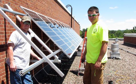 Technicians from Eland Electric install a solar panel array on the roof of Newman Catholic High School, June 18 2013 Technicians from Eland Electric install a solar panel array on the roof of Newman Catholic High School, June 18 2013