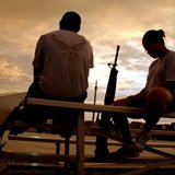 U.S. soldiers from the NATO-led coalition force relax beside a basketball court as night falls at the Kandahar Air Field, Afghanistan, June 