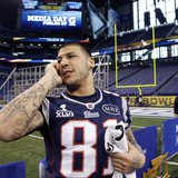 New England Patriots tight end Aaron Hernandez talks on a phone during media day for the NFL Super Bowl XLVI in Indianapolis January 31, 201