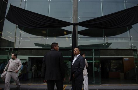 Presidential guards stand in front a black ribbon after a tribute for the victims of an explosion at the headquarters of the state oil monop Presidential guards stand in front a black ribbon after a tribute for the victims of an explosion at the headquarters of the state oil monop