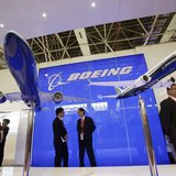 Visitors chat in front of models of the 777-300ER (L) and 737-8 MAX passenger planes, with a scale of 1:40, at the Boeing booth on the first