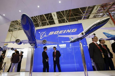 Visitors chat in front of models of the 777-300ER (L) and 737-8 MAX passenger planes, with a scale of 1:40, at the Boeing booth on the first Visitors chat in front of models of the 777-300ER (L) and 737-8 MAX passenger planes, with a scale of 1:40, at the Boeing booth on the first