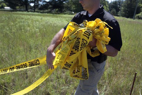 A federal investigator carries yellow crime tape at a field which investigators are prepared to dig up for the remains of former Teamsters b A federal investigator carries yellow crime tape at a field which investigators are prepared to dig up for the remains of former Teamsters b