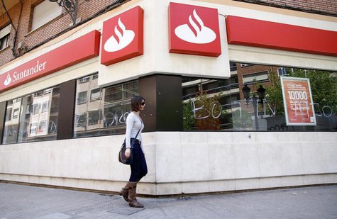 A woman walks past the vandalized windows of a Banco Santander branch in Valencia, May 14, 2013. The words on the windows read, "Botin" (a r A woman walks past the vandalized windows of a Banco Santander branch in Valencia, May 14, 2013. The words on the windows read, "Botin" (a r