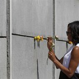 U.S. first lady Michelle Obama (L) and her daughter Sasha place flowers as they visit the Berlin Wall memorial in Bernauer Strasse in Berlin
