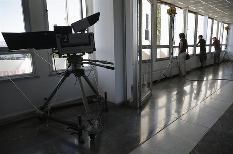 Employees stand by the windows inside the Greek state television ERT headquarters at Aghia Paraskevi suburb in Athens June 18, 2013. REUTERS Employees stand by the windows inside the Greek state television ERT headquarters at Aghia Paraskevi suburb in Athens June 18, 2013. REUTERS