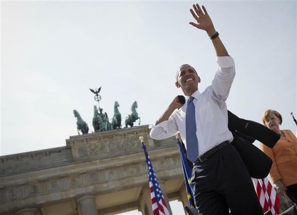 German Chancellor Angela Merkel watches as U.S. President Barack Obama waves after giving a speech in front of the Brandenburg Gate in Berli German Chancellor Angela Merkel watches as U.S. President Barack Obama waves after giving a speech in front of the Brandenburg Gate in Berli