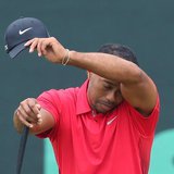 Tiger Woods of the U.S. wipes his face while on the second green during the final round of the 2013 U.S. Open golf championship at the Merio