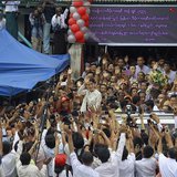 Myanmar pro-democracy leader Aung San Suu Kyi waves to supporters as she leaves the National League for Democracy party headquarters after a