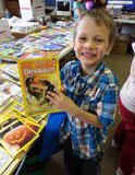Noah Thurman, first grade, excited about a non-fiction dinosaur book