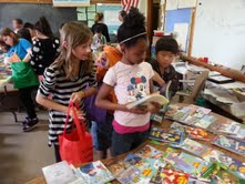 Fourth graders: Angelina Hinz, Chardonnay Traylor, Peter Vang, Aliziah Blevons (in the background holding the green bag) selecting their new books. Fourth graders: Angelina Hinz, Chardonnay Traylor, Peter Vang, Aliziah Blevons (in the background holding the green bag) selecting their new books.