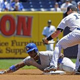 Los Angeles Dodgers' Yasiel Puig is tagged out by New York Yankees shortstop Jayson Nix (R) as Puig attempts to stretch a single into a doub