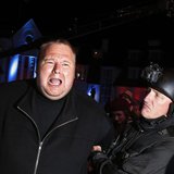 An actor in police costume mock-arrests Megaupload founder Kim Dotcom (L) as he launches his new file sharing site "Mega" in Auckland Januar