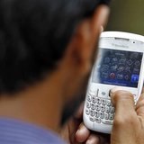 A man checks his mobile phone near a marketplace in New Delhi June 18, 2013. REUTERS/Anindito Mukherjee