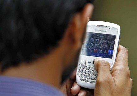A man checks his mobile phone near a marketplace in New Delhi June 18, 2013. REUTERS/Anindito Mukherjee A man checks his mobile phone near a marketplace in New Delhi June 18, 2013. REUTERS/Anindito Mukherjee