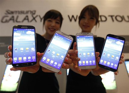 Models pose for photographers with Samsung Electronics Co Ltd's latest flagship smartphone S4 during its launch event at the company's headq Models pose for photographers with Samsung Electronics Co Ltd's latest flagship smartphone S4 during its launch event at the company's headq