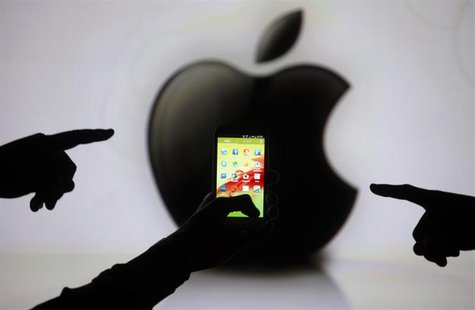 Men are silhouetted against a video screen with an Apple Inc logo as they pose with a Samsung Galaxy S3 smartphone in this photo illustratio Men are silhouetted against a video screen with an Apple Inc logo as they pose with a Samsung Galaxy S3 smartphone in this photo illustratio